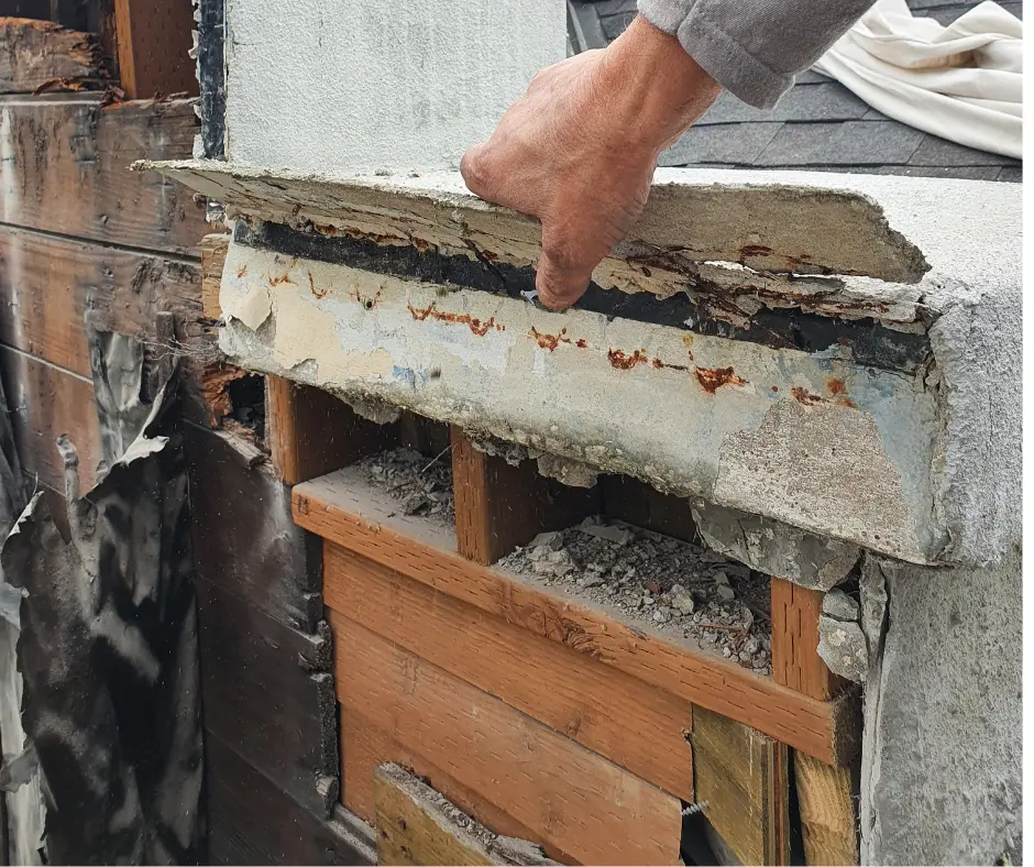 Exposed water damage and rust on stucco facade of historic Portland home