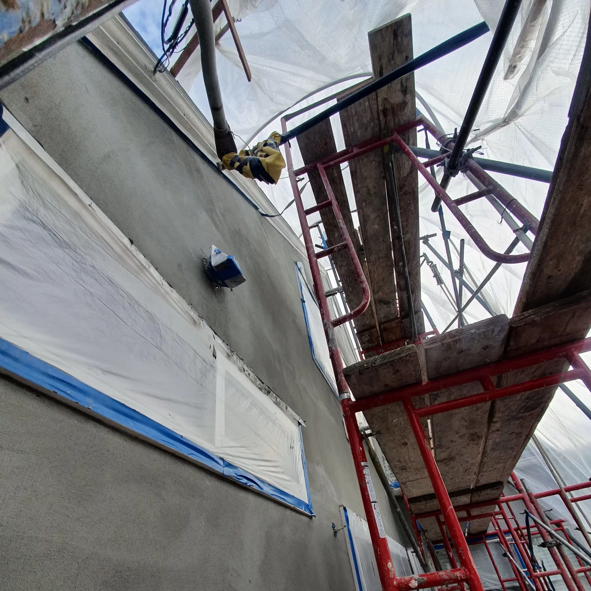 Close-up of stucco being applied to a wall, eliminating the need for painting during winter repairs.